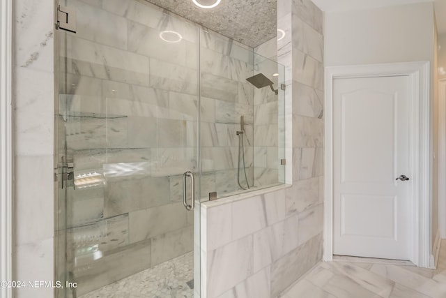 bathroom with a stall shower and marble finish floor