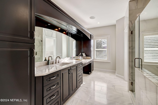 full bathroom featuring a sink, baseboards, marble finish floor, a shower stall, and double vanity