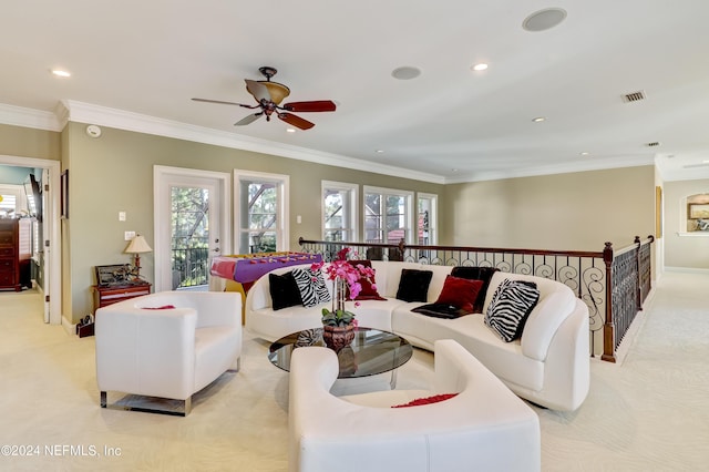 living room featuring plenty of natural light, crown molding, and light colored carpet