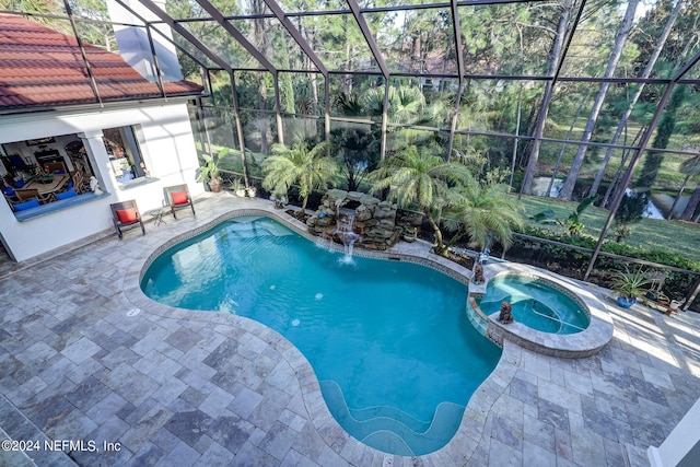 view of swimming pool featuring glass enclosure, a pool with connected hot tub, and a patio area