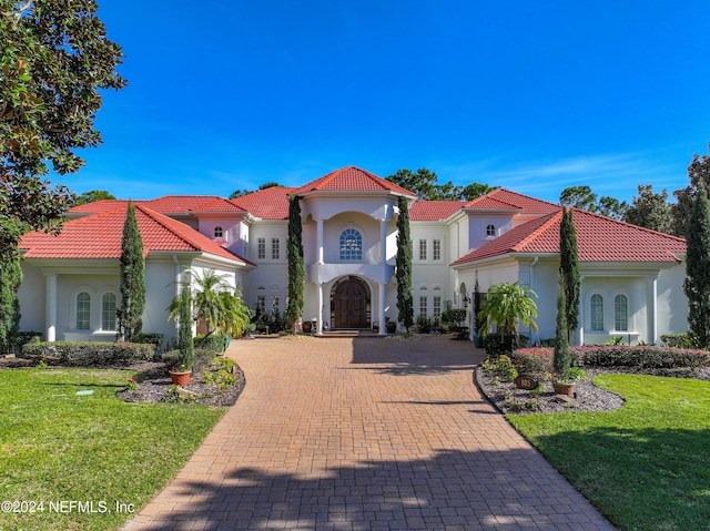 mediterranean / spanish-style home with a front yard