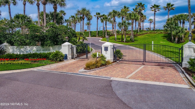 view of gate with a lawn and fence