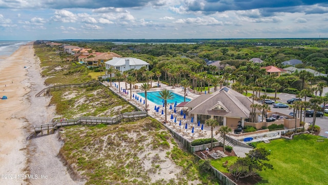 birds eye view of property featuring a water view and a beach view