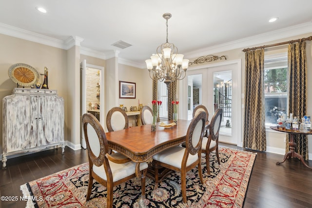 dining space featuring dark wood-style floors, visible vents, crown molding, and baseboards