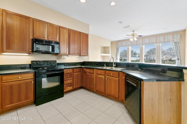 kitchen featuring sink, light tile patterned floors, black appliances, and a textured ceiling