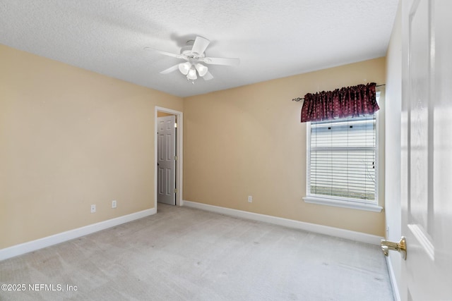 carpeted empty room featuring ceiling fan and a textured ceiling