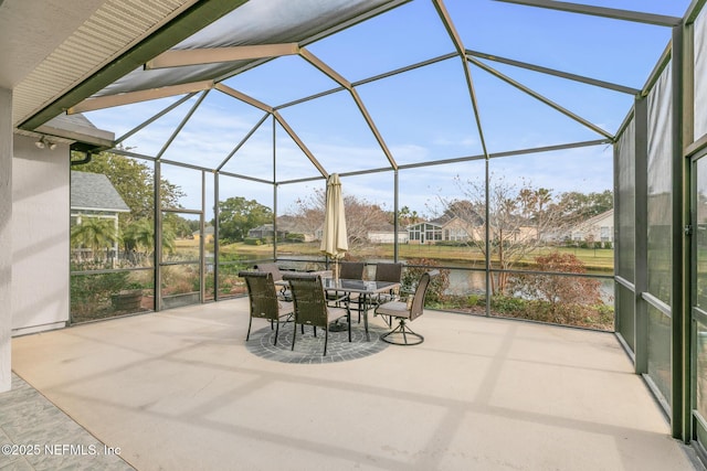 sunroom featuring a water view