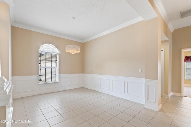 empty room with light tile patterned flooring, ornamental molding, a notable chandelier, and a textured ceiling