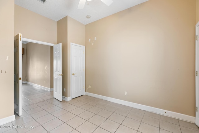 tiled spare room featuring lofted ceiling, a textured ceiling, and ceiling fan