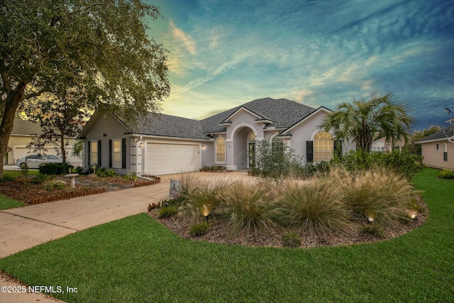 ranch-style home with a garage and a lawn