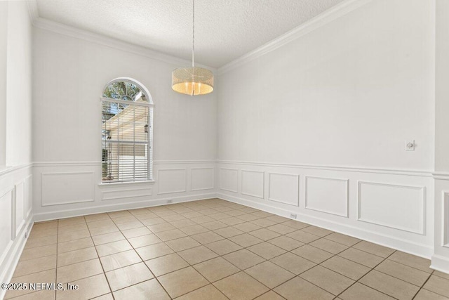 unfurnished room with light tile patterned floors, a textured ceiling, and ornamental molding