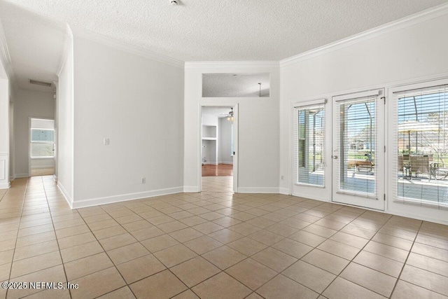 spare room with light tile patterned floors, a textured ceiling, crown molding, and a ceiling fan