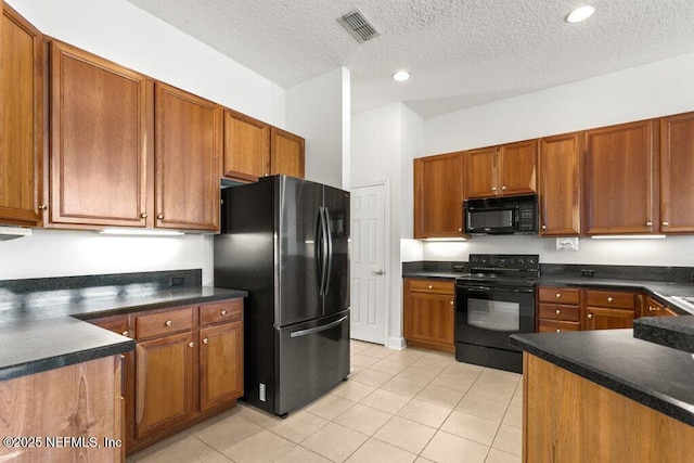 kitchen featuring dark countertops, visible vents, brown cabinets, and black appliances