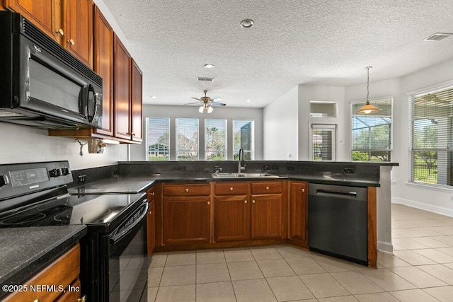 kitchen with black appliances, dark countertops, visible vents, and a sink