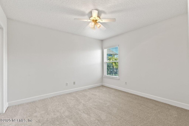 empty room featuring ceiling fan, carpet, baseboards, and a textured ceiling