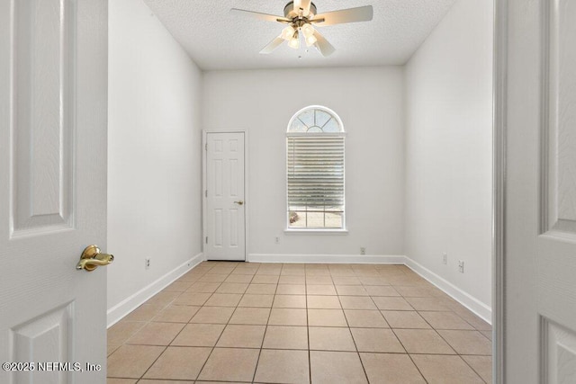 unfurnished room featuring light tile patterned floors, plenty of natural light, a textured ceiling, and ceiling fan
