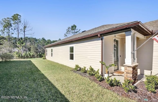 view of side of property featuring a lawn and a porch