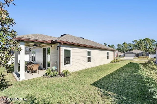 back of property with ceiling fan, a patio area, and a yard