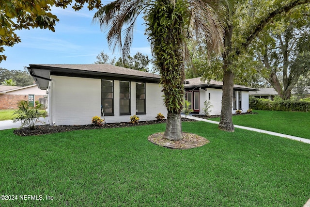 single story home featuring a front lawn