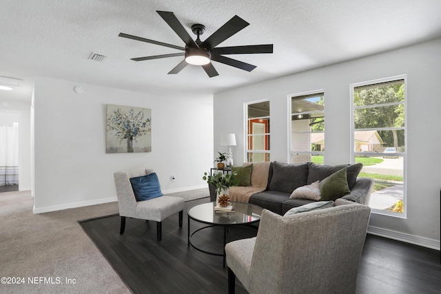 carpeted living room with a textured ceiling and ceiling fan