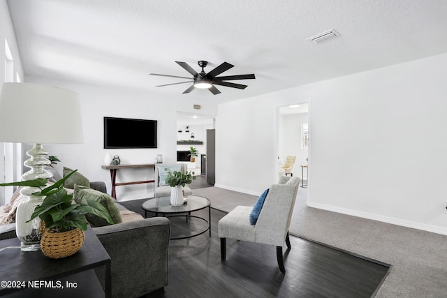 living room featuring ceiling fan and a textured ceiling