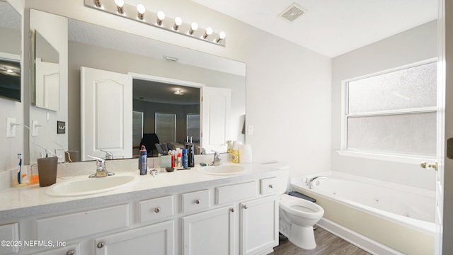 bathroom with a tub to relax in, toilet, vanity, and hardwood / wood-style flooring