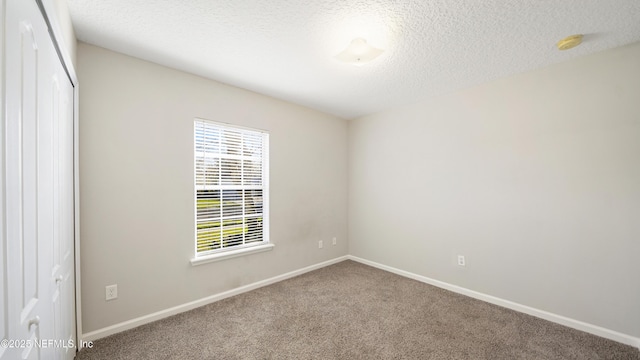 carpeted spare room with a textured ceiling