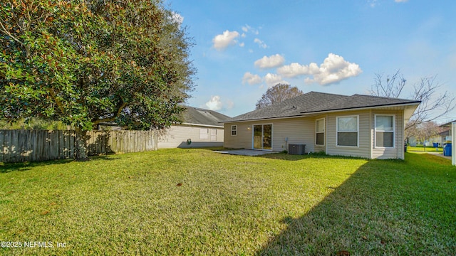 back of house with cooling unit, a patio area, and a lawn