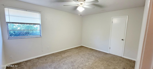 carpeted spare room featuring ceiling fan