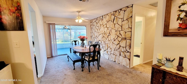 dining area with light carpet, a textured ceiling, and ceiling fan