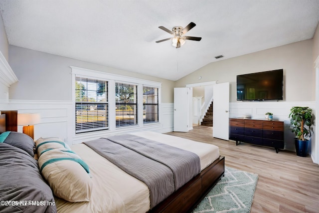 bedroom featuring ceiling fan, lofted ceiling, and light wood-type flooring