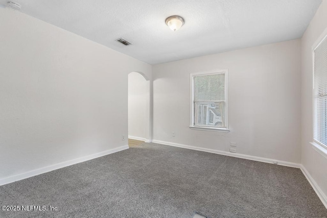 carpeted spare room with a textured ceiling