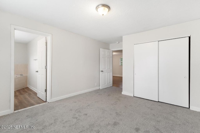 unfurnished bedroom featuring connected bathroom, light carpet, and a closet