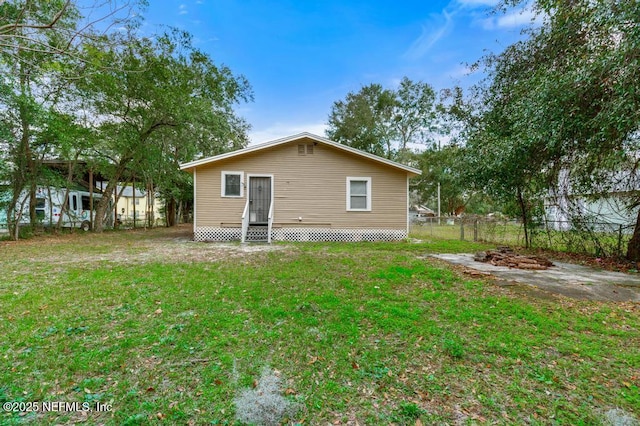 rear view of house featuring a yard