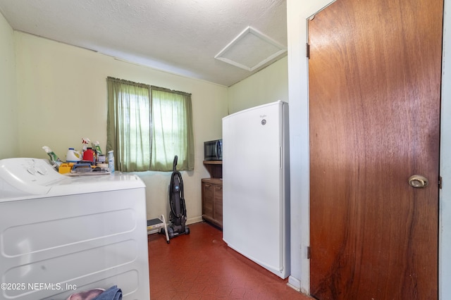 laundry area featuring washing machine and dryer and a textured ceiling