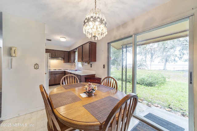 dining area featuring a notable chandelier and sink