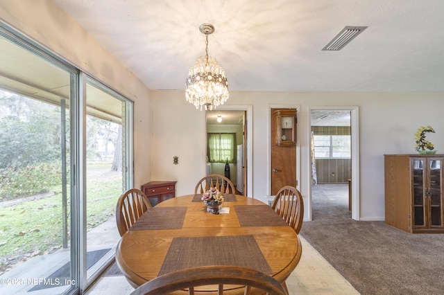 dining area featuring carpet floors and a notable chandelier