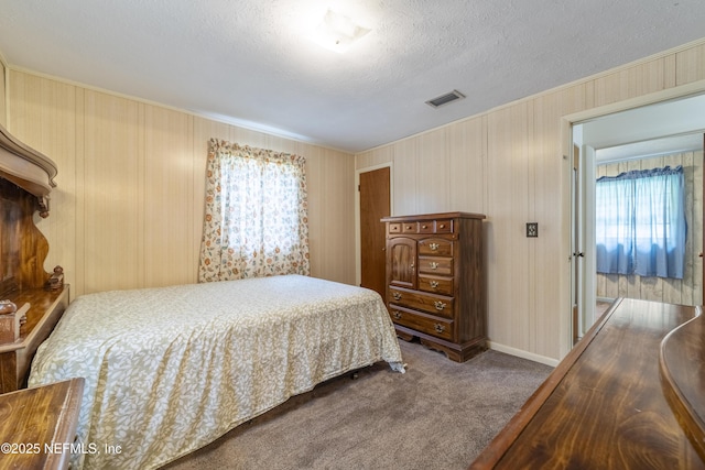 bedroom featuring a textured ceiling, light colored carpet, and multiple windows