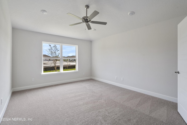 unfurnished room featuring ceiling fan, carpet floors, and a textured ceiling