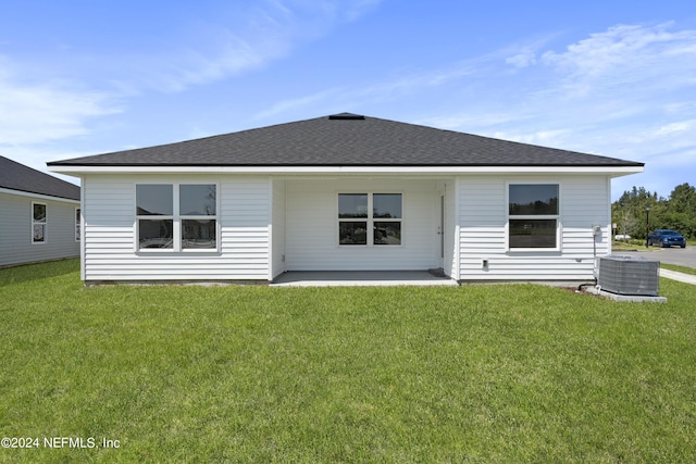 rear view of property with a yard, a patio area, and central AC