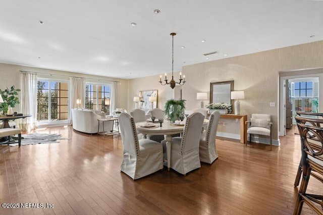 dining space featuring dark hardwood / wood-style floors and a notable chandelier