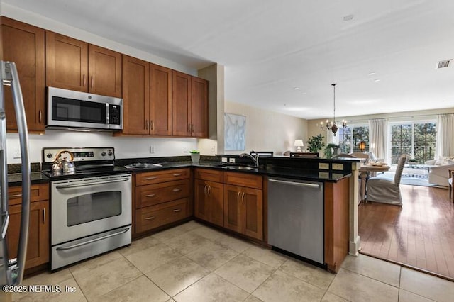 kitchen with sink, stainless steel appliances, kitchen peninsula, and light tile patterned floors