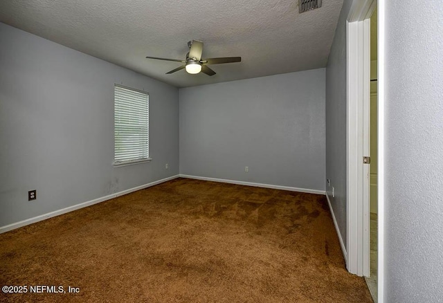 empty room with ceiling fan, dark carpet, and a textured ceiling