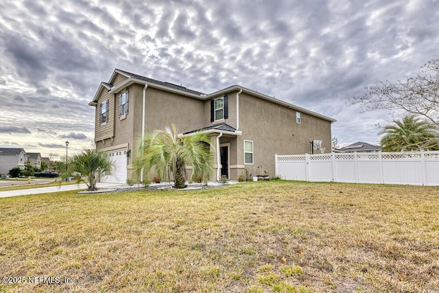 view of front of property featuring a front yard and a garage