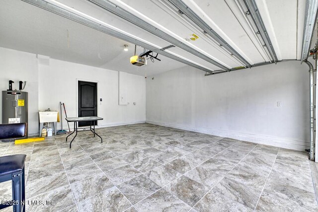 garage featuring electric water heater, a garage door opener, and sink