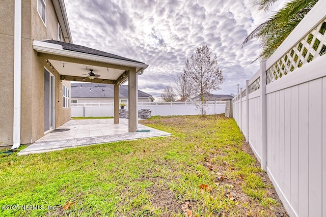 view of yard featuring ceiling fan and a patio