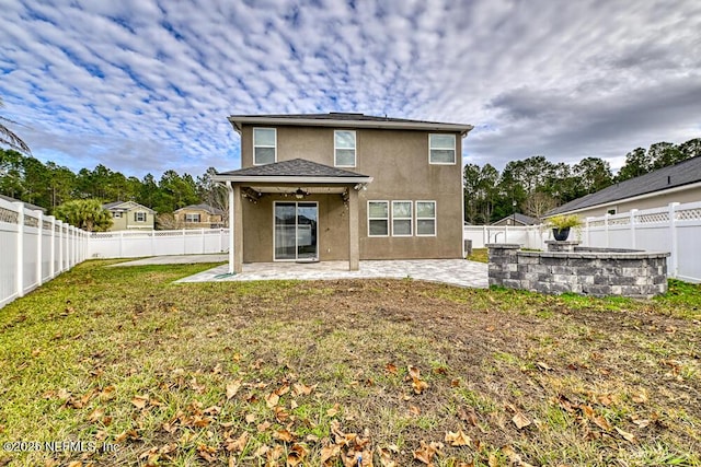 rear view of property featuring a yard, a patio, and ceiling fan