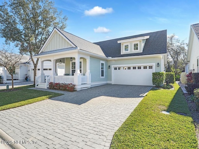 view of front facade featuring a garage, a porch, and a front yard