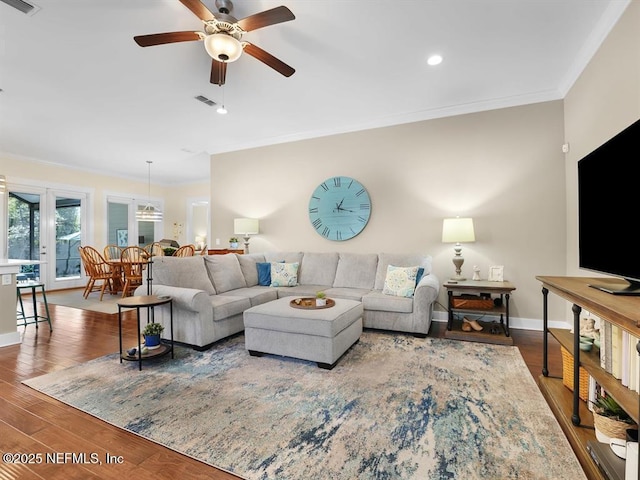 living room featuring hardwood / wood-style floors, ceiling fan, and crown molding