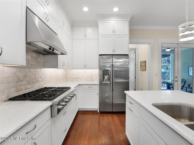 kitchen featuring crown molding, tasteful backsplash, decorative light fixtures, white cabinetry, and stainless steel appliances